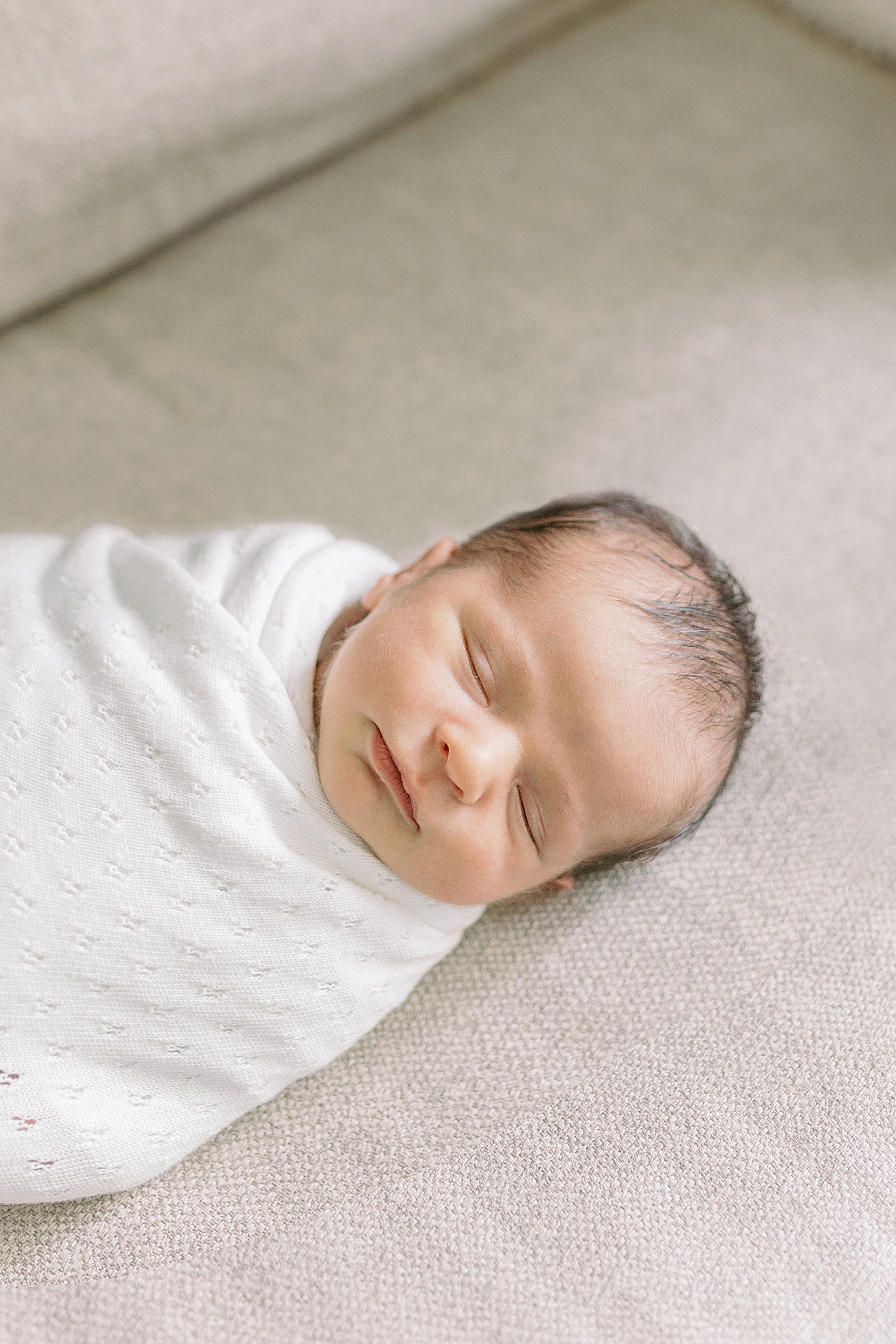 Newborn baby sleeping on a couch | Photo by Caitlyn Motycka Photography