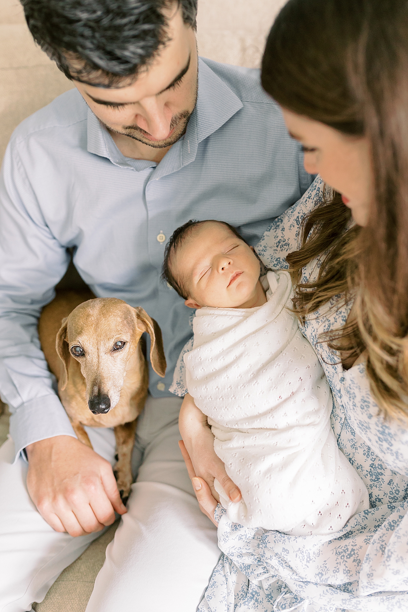 Family snuggling with their newborn baby | Photo by Mount Pleasant Newborn Photographer Caitlyn Motycka