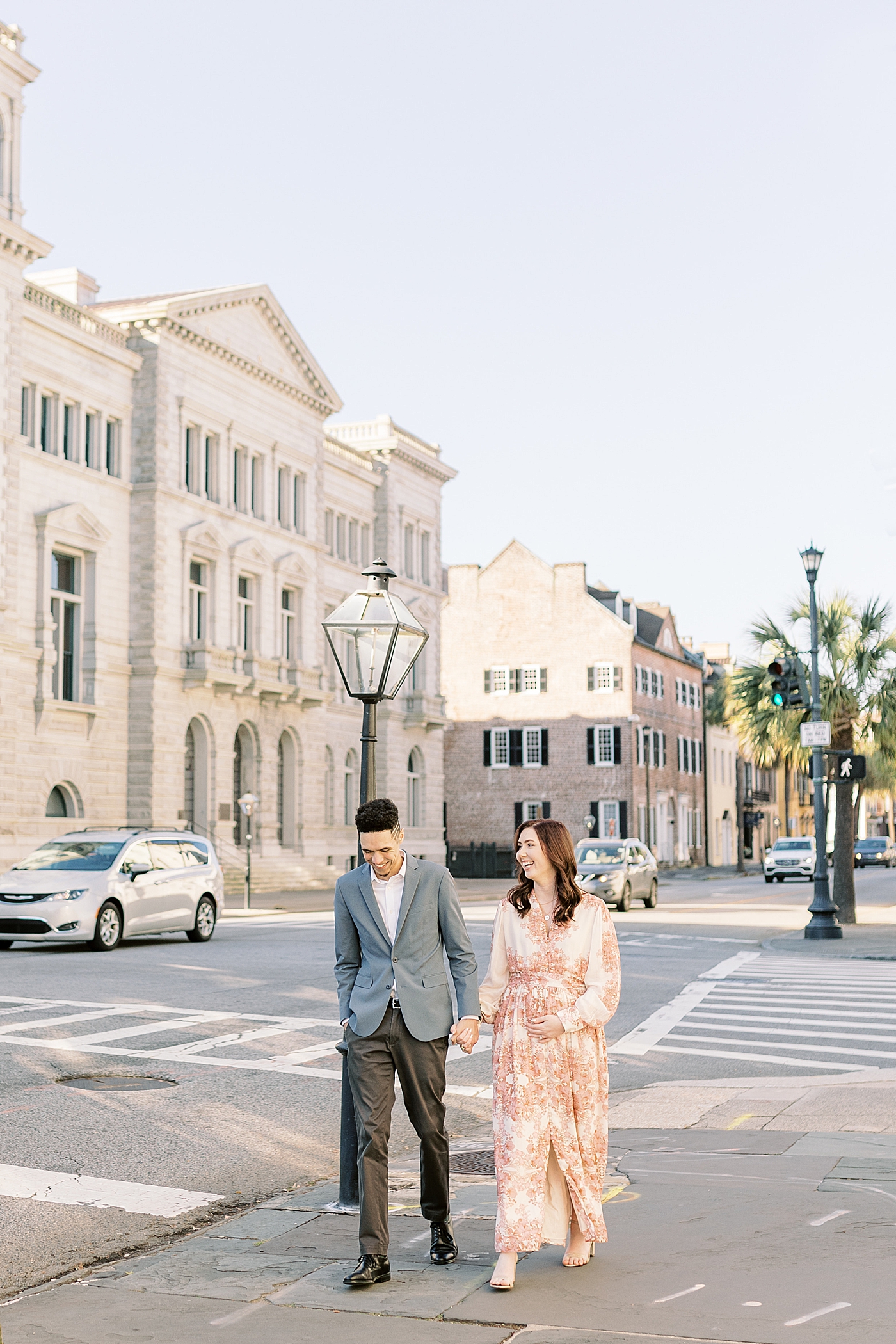 Couple walking down the street during their Pregnancy Announcement in Downtown Charleston | Photo by Caitlyn Motycka Photography