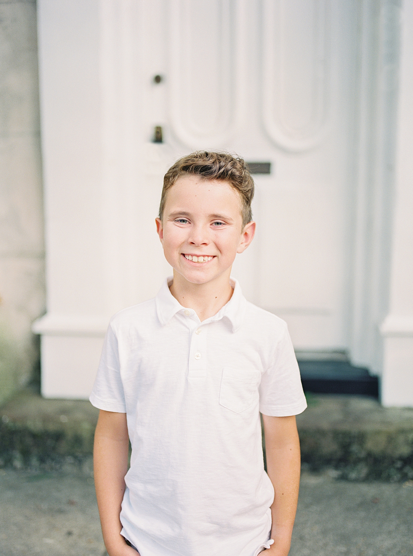 Little boy in a white shirt smiling | Photo by Caitlyn Motycka Photography