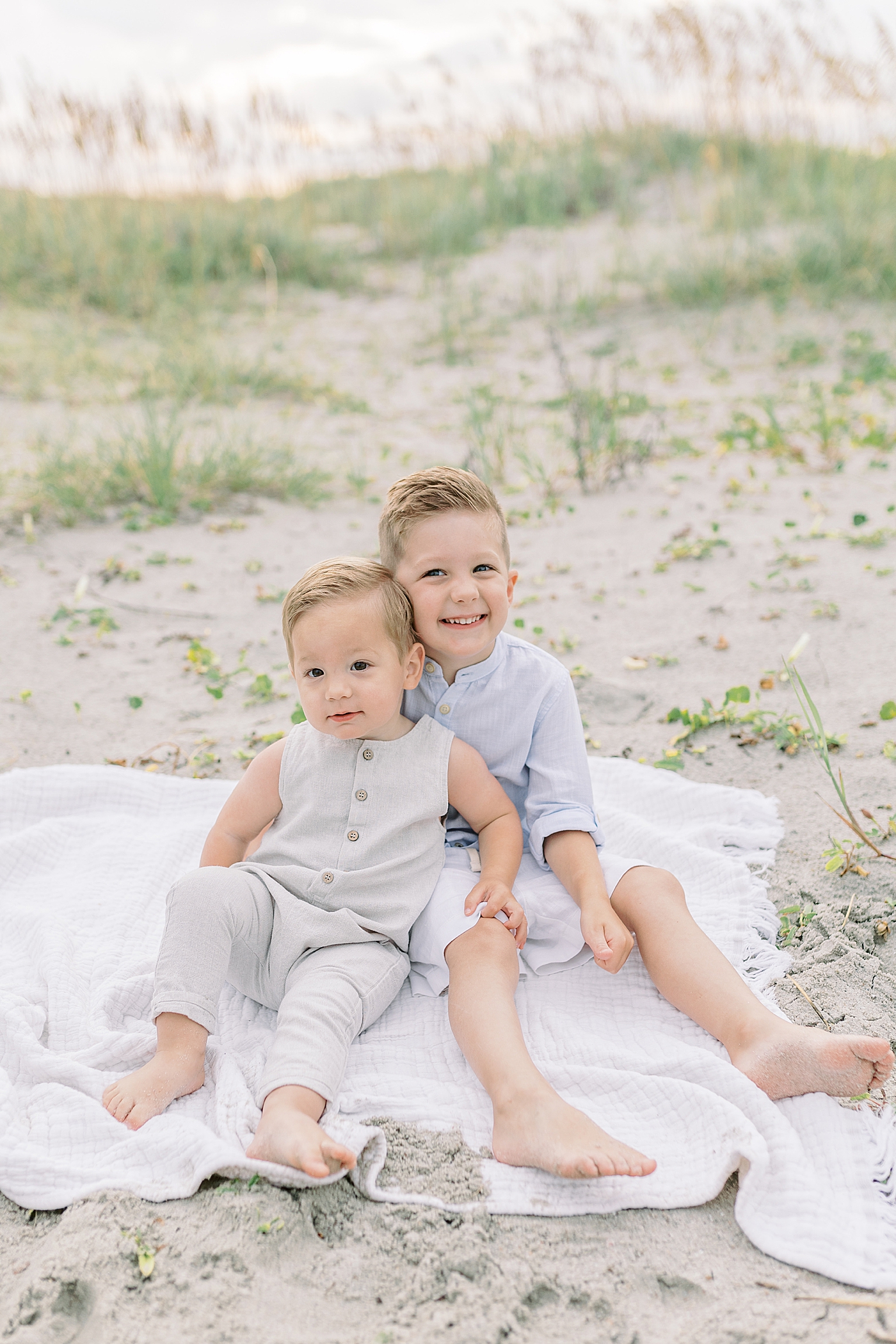 Brothers sitting on a beach blanket | Preparing for Family Beach Session with Caitlyn Motycka