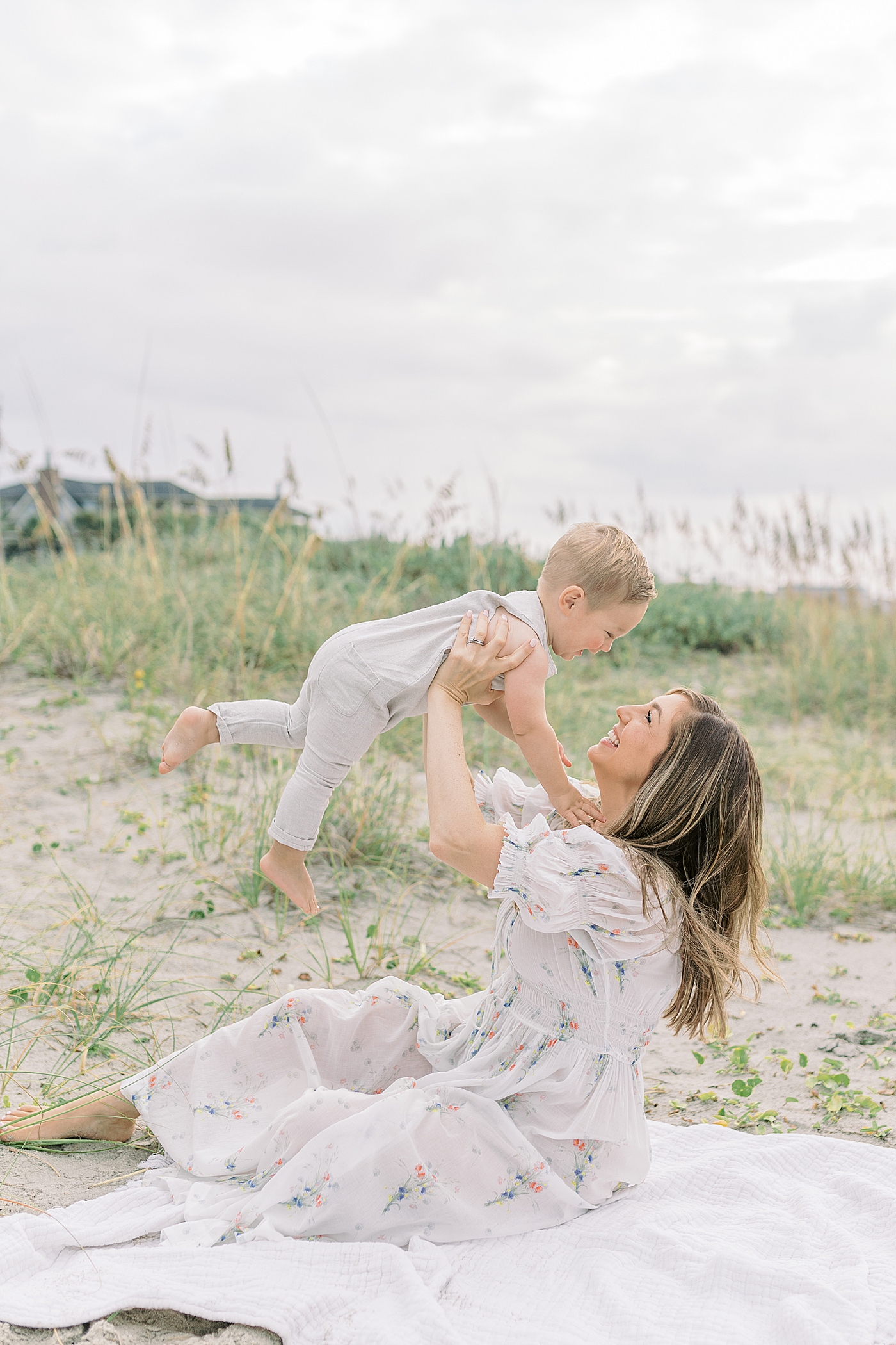 Mom playing with her baby boy on the beach | Image by Caitlyn Motycka