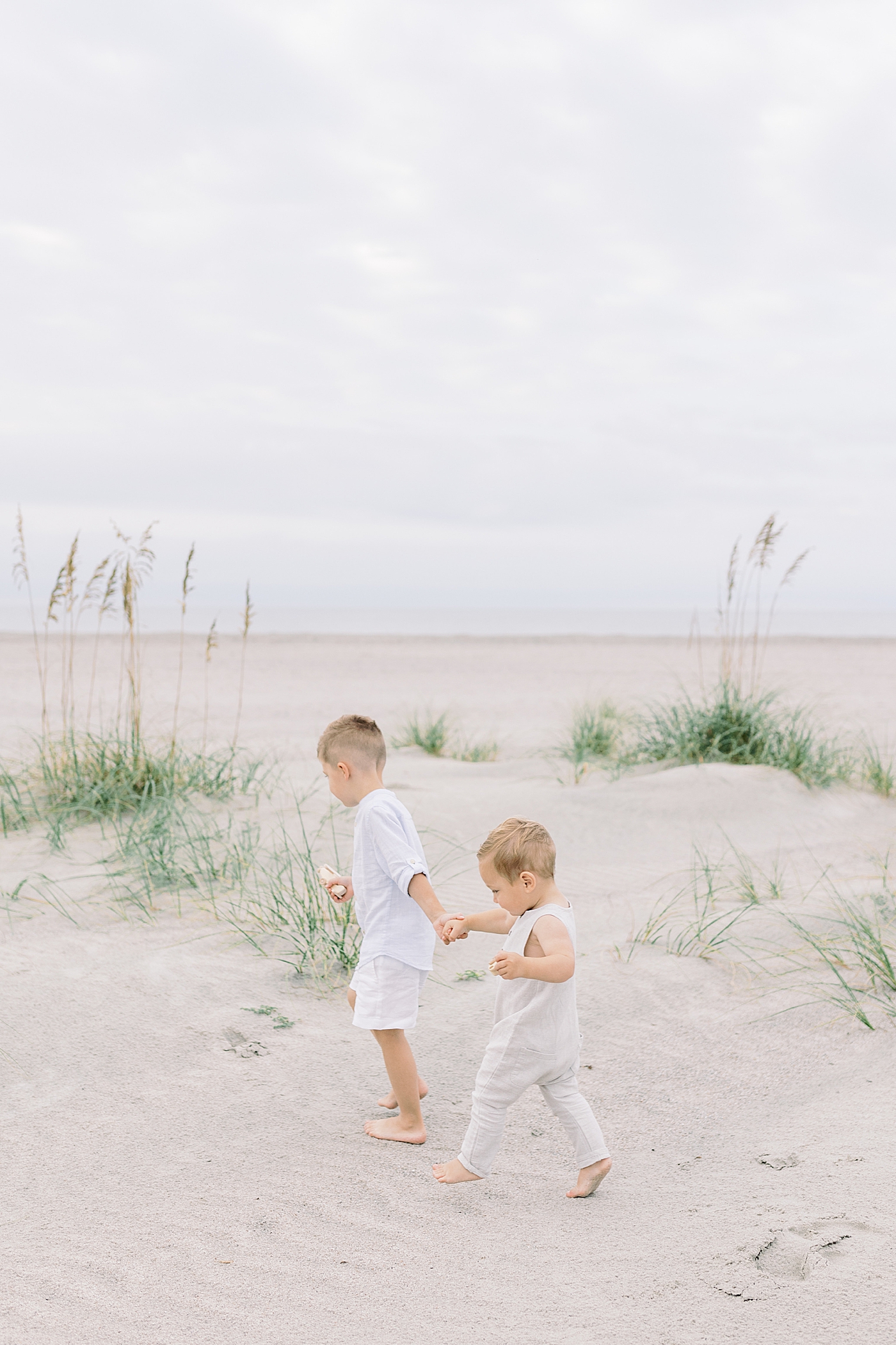 Toddler brothers walking on the beach | Image by Caitlyn Motycka