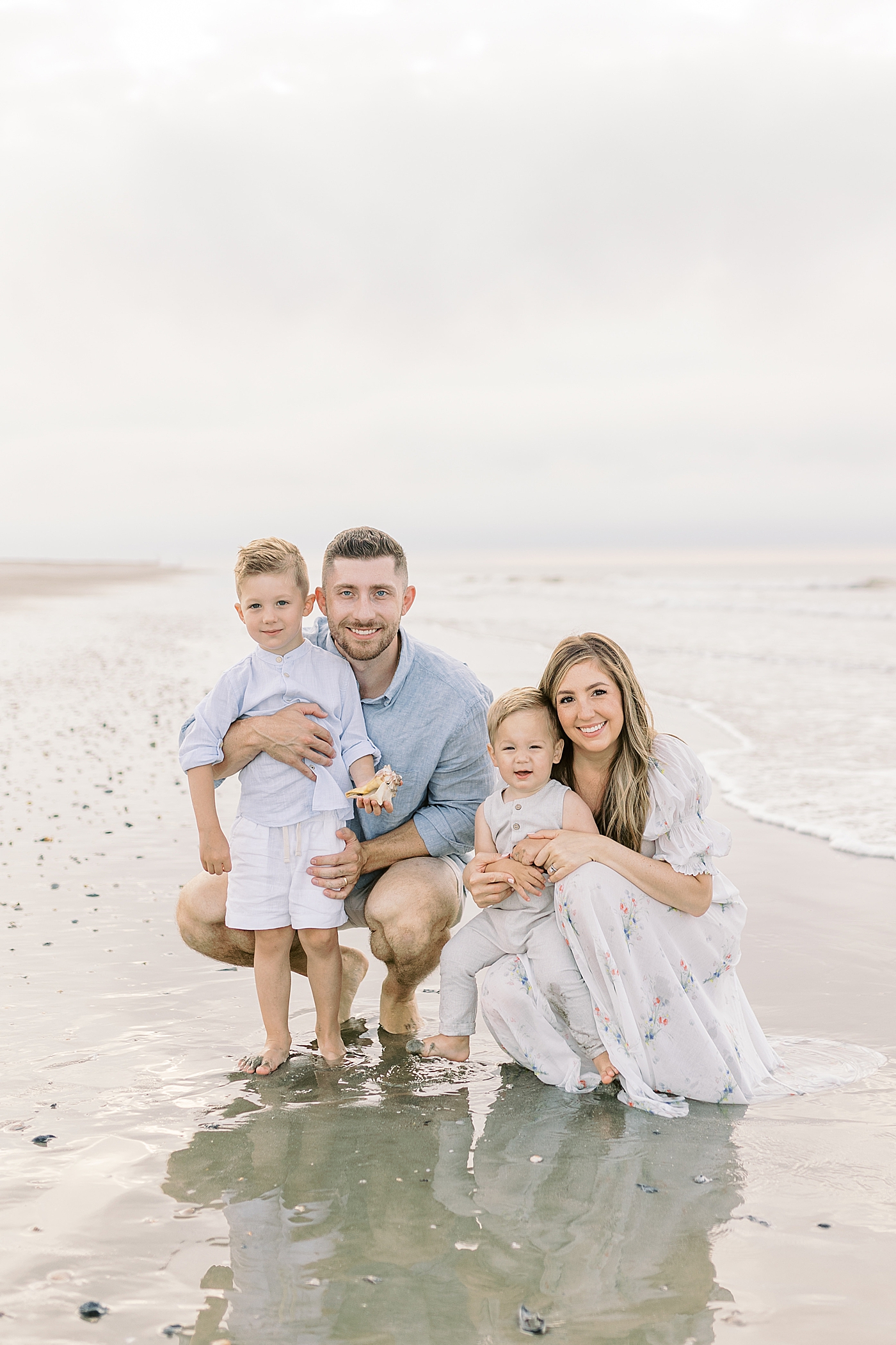 Family of four snuggling near the ocean | Preparing for Family Beach Session with Caitlyn Motycka