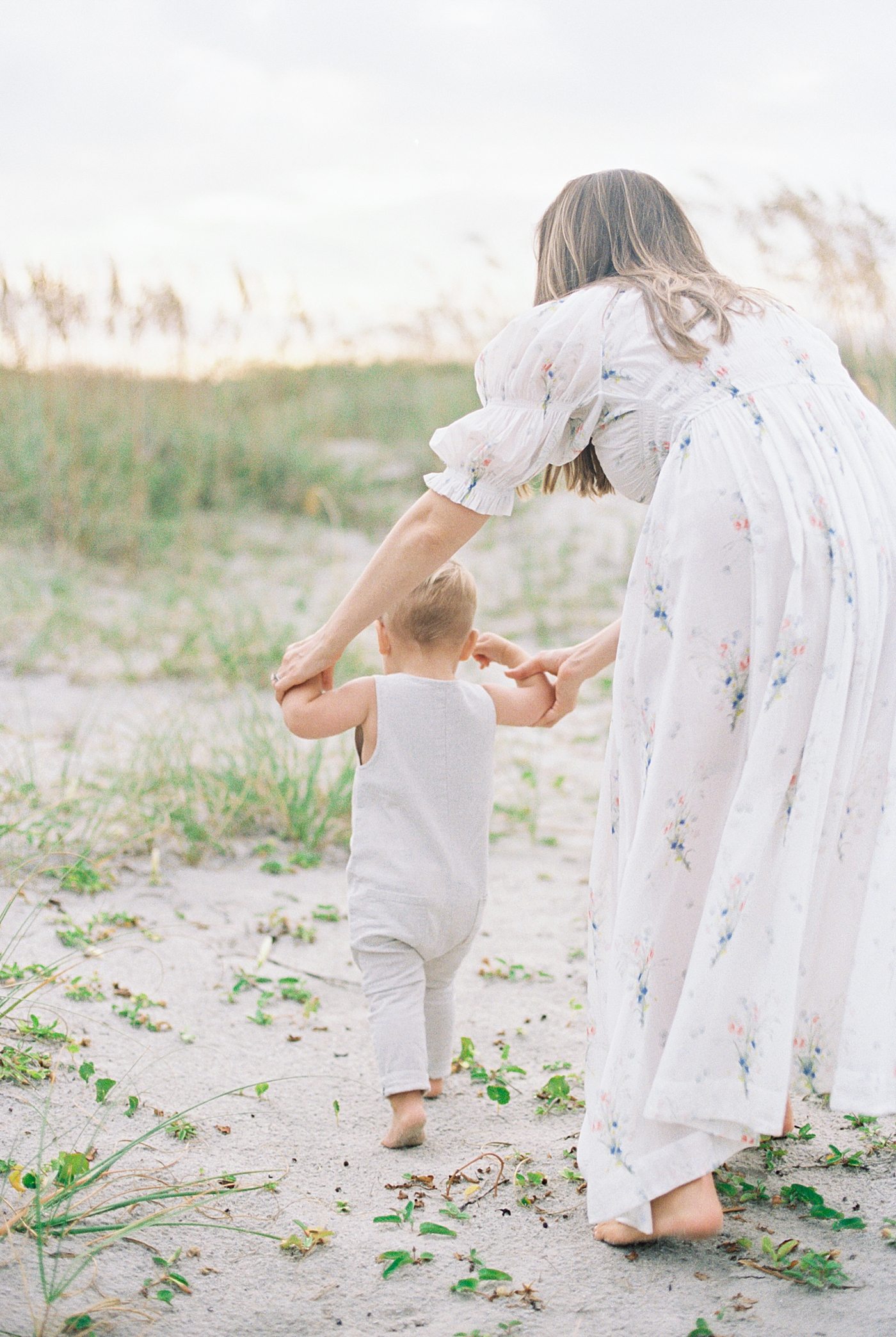 Mom helping her baby boy walk on the beach | Preparing for Family Beach Session with Caitlyn Motycka