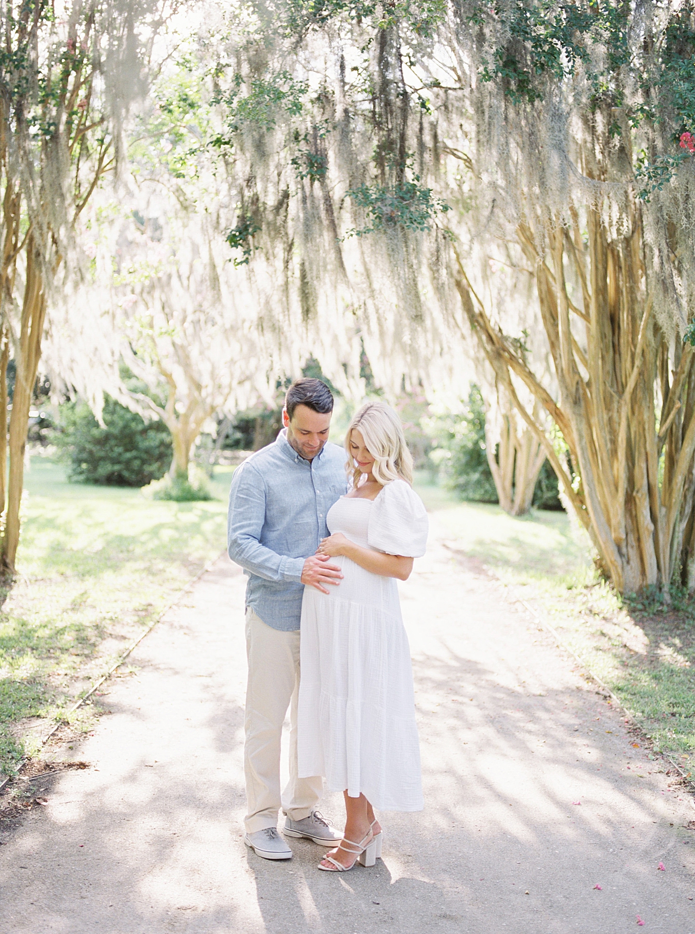 Mom and dad snuggling under Spanish moss covered path | Dad's Wardrobe Fall Sessions with Caitlyn Motycka Photography
