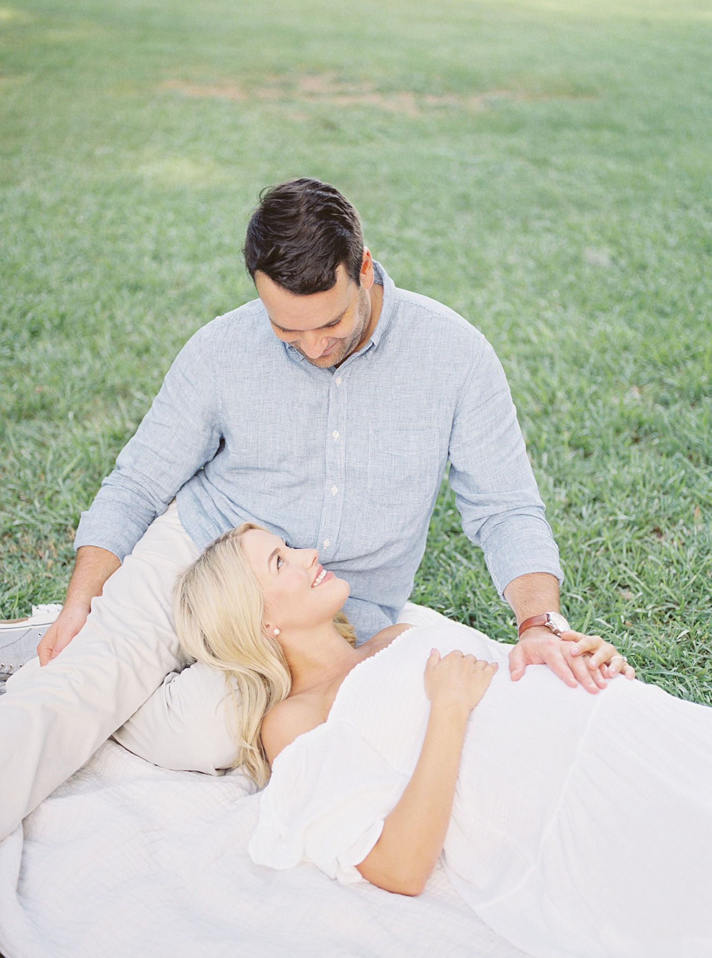 Mom and dad to be sitting in the grass in the park | Images by Caitlyn Motycka
