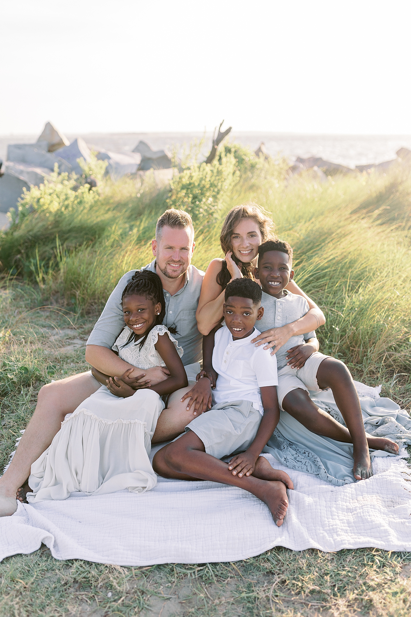 Family of five sitting on a picnic blanket | Image by Caitlyn Motycka
