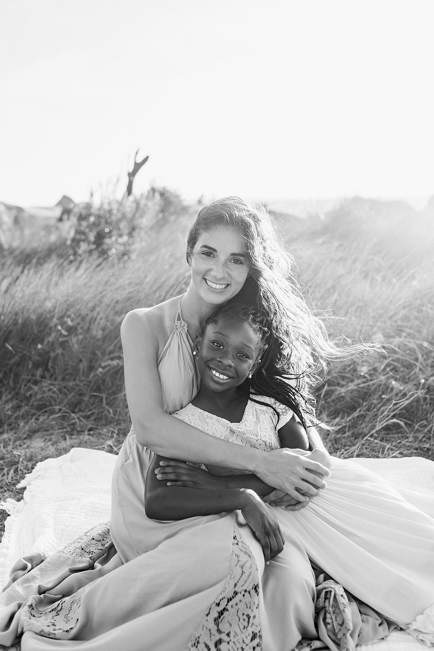 Black and white image of mom and daughter during beach family photos in Charleston | Image by Caitlyn Motycka