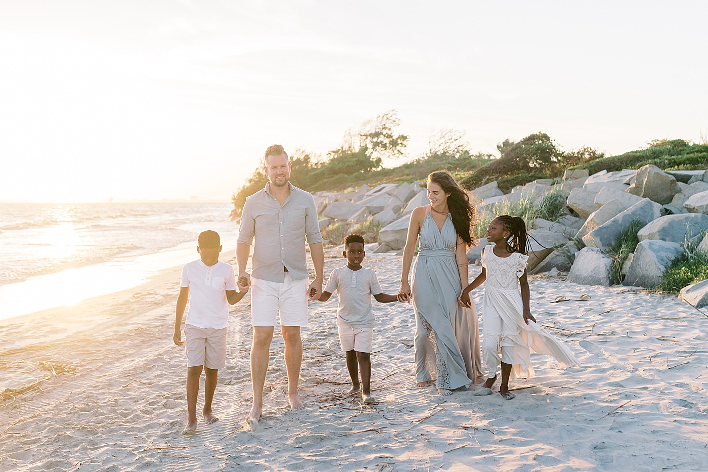 Family of five walking on the beach | Image by Caitlyn Motycka