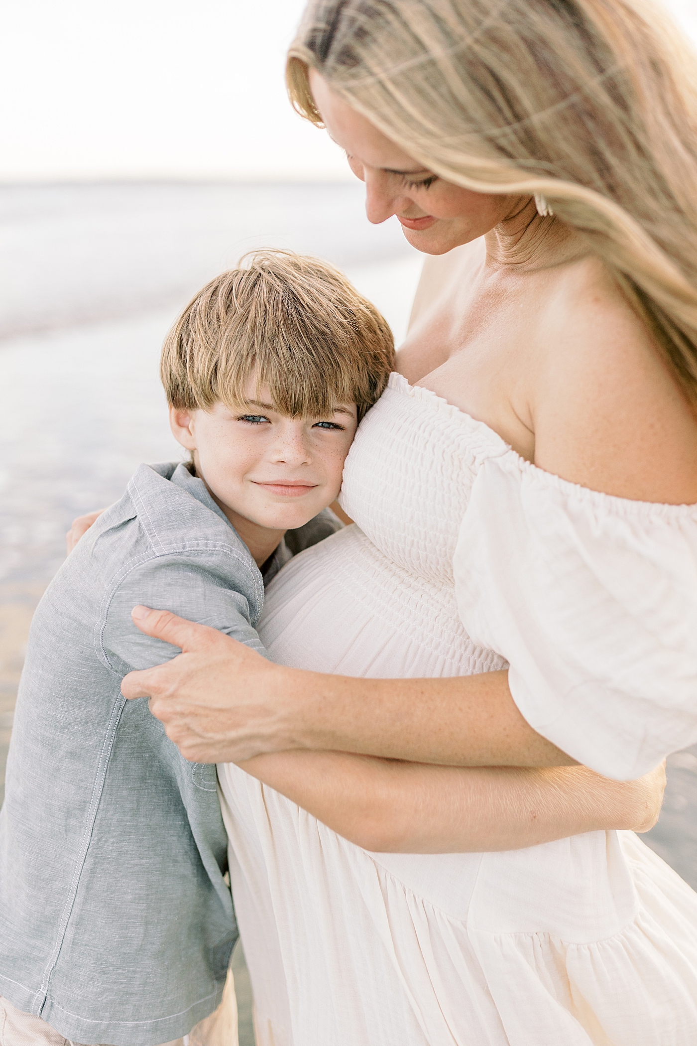 Little boy hugging his mom during their Maternity Session at Folly Beach | Image by Caitlyn Motycka