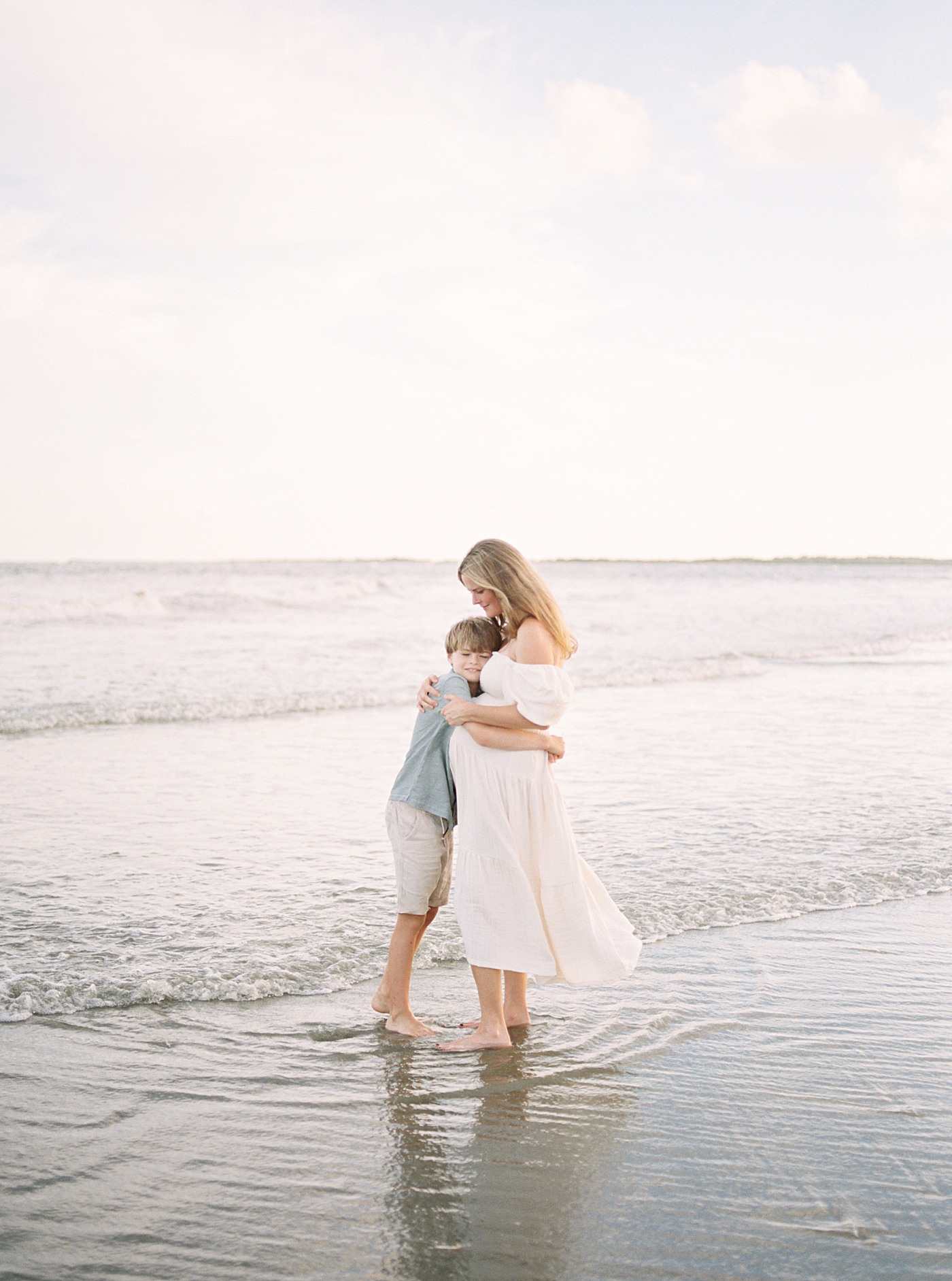 Pregnant mom hugging her little boy during their Maternity Session at Folly Beach | Image by Caitlyn Motycka