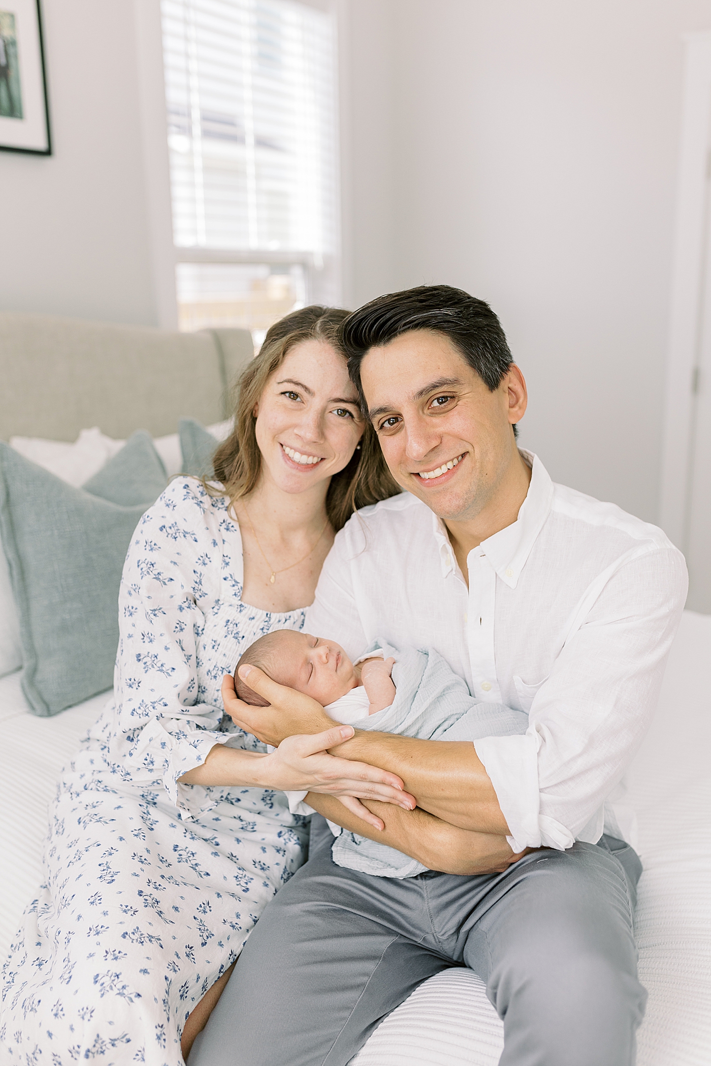 Mom and dad holding their new baby during lifestyle newborn photos | Image by Caitlyn Motycka