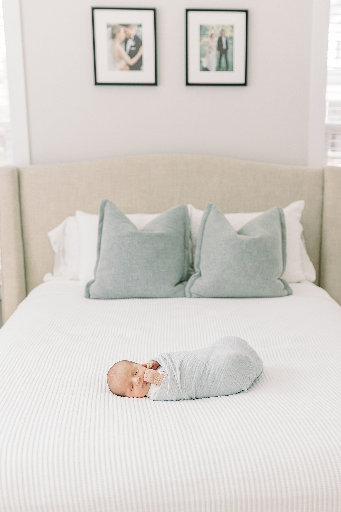 Newborn baby sleeping on a bed during lifestyle newborn photos | Image by Caitlyn Motycka