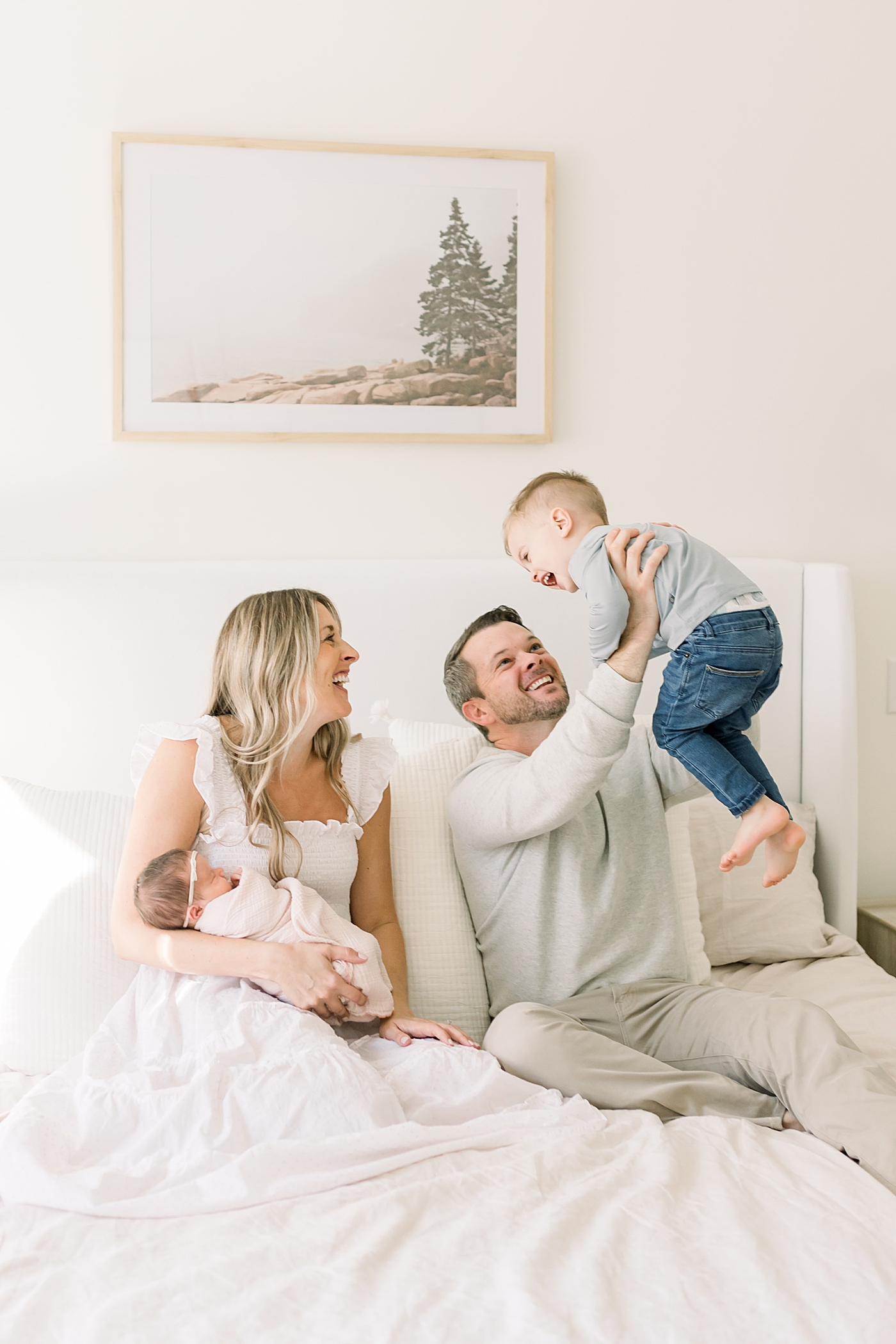 Mom and dad playing with their toddler boy and holding their newborn | Newborn Photos with Toddler with Caitlyn Motycka Photography