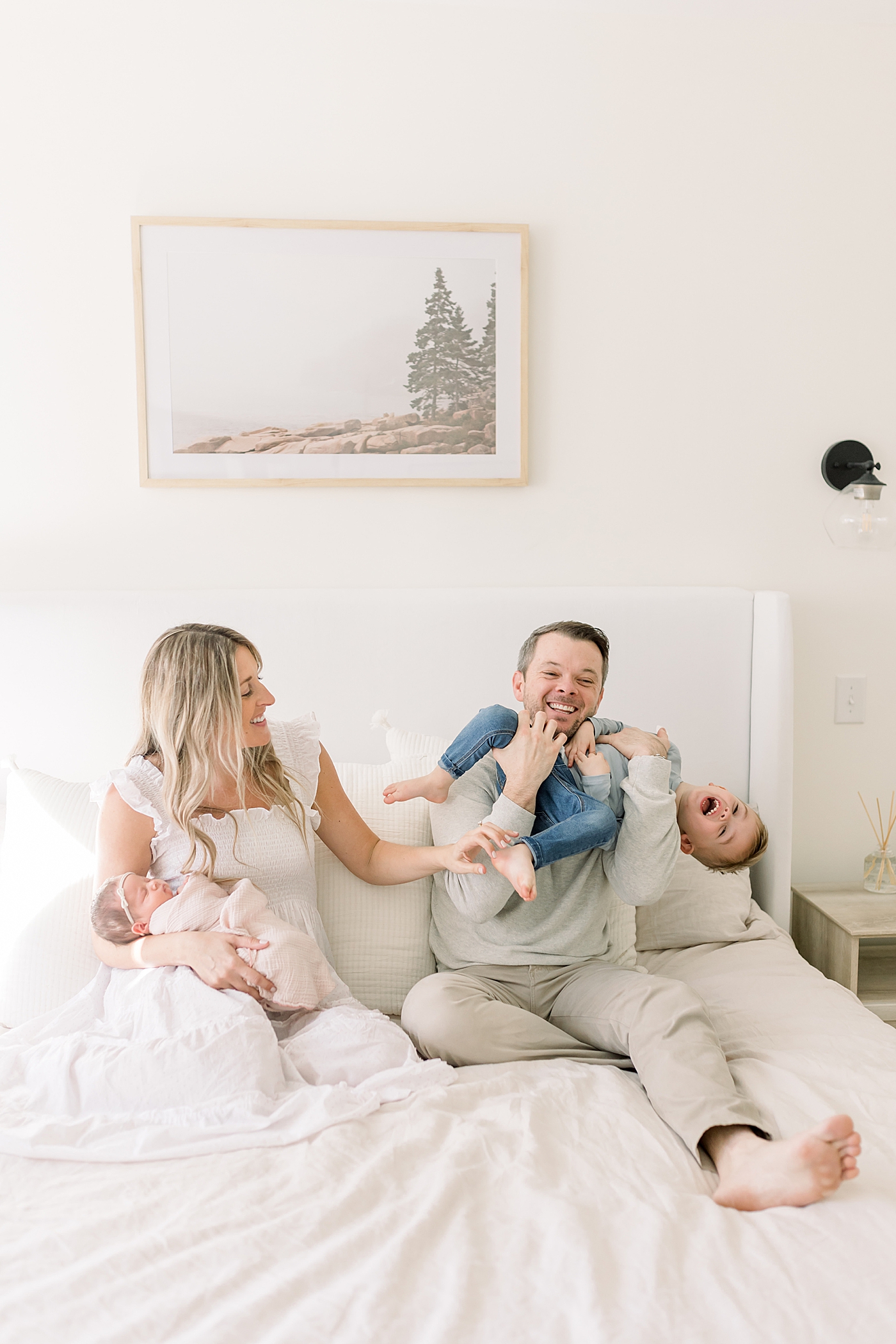 Mom and dad playing with their toddler and holding their new baby | Newborn Photos with Toddler with Caitlyn Motycka Photography