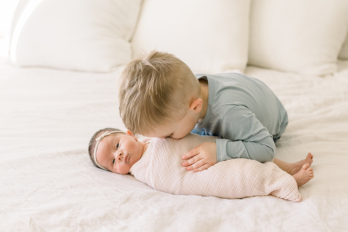 Toddler boy hugging his new baby sister | Image by Caitlyn Motycka