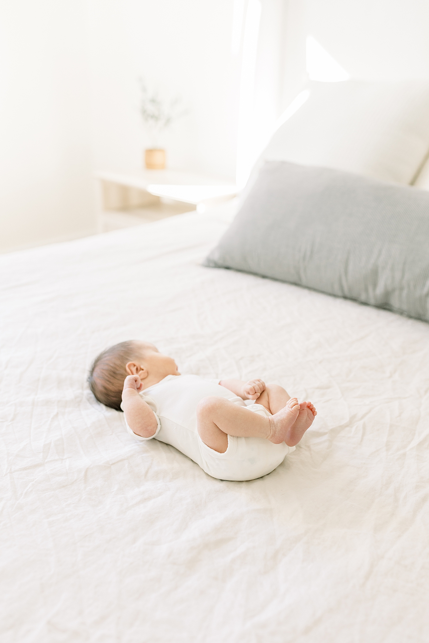 Newborn baby girl in a white onesie | Image by Caitlyn Motycka