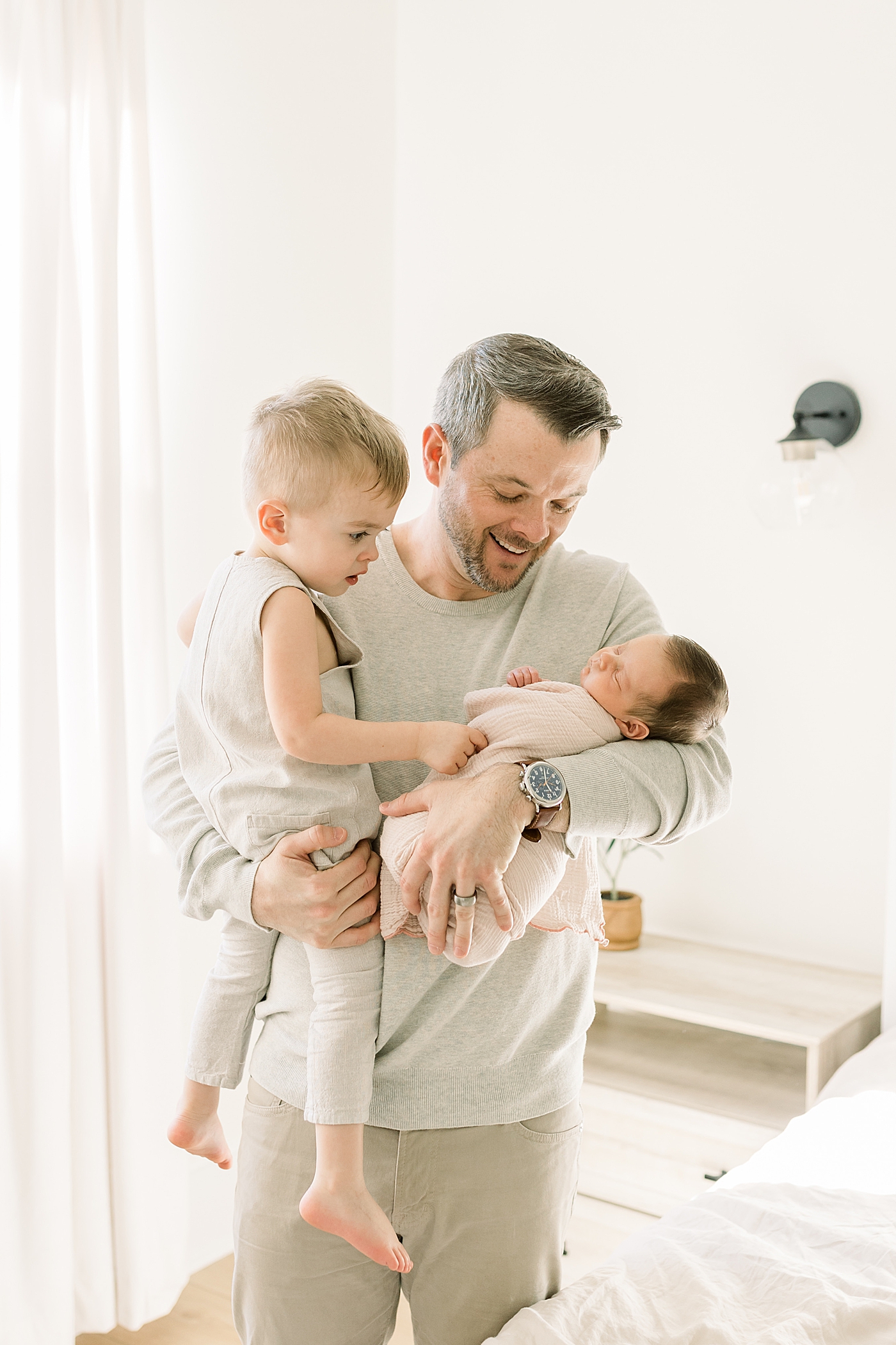 Dad holding his toddler and new baby girl | Newborn Photos with Toddler with Caitlyn Motycka Photography