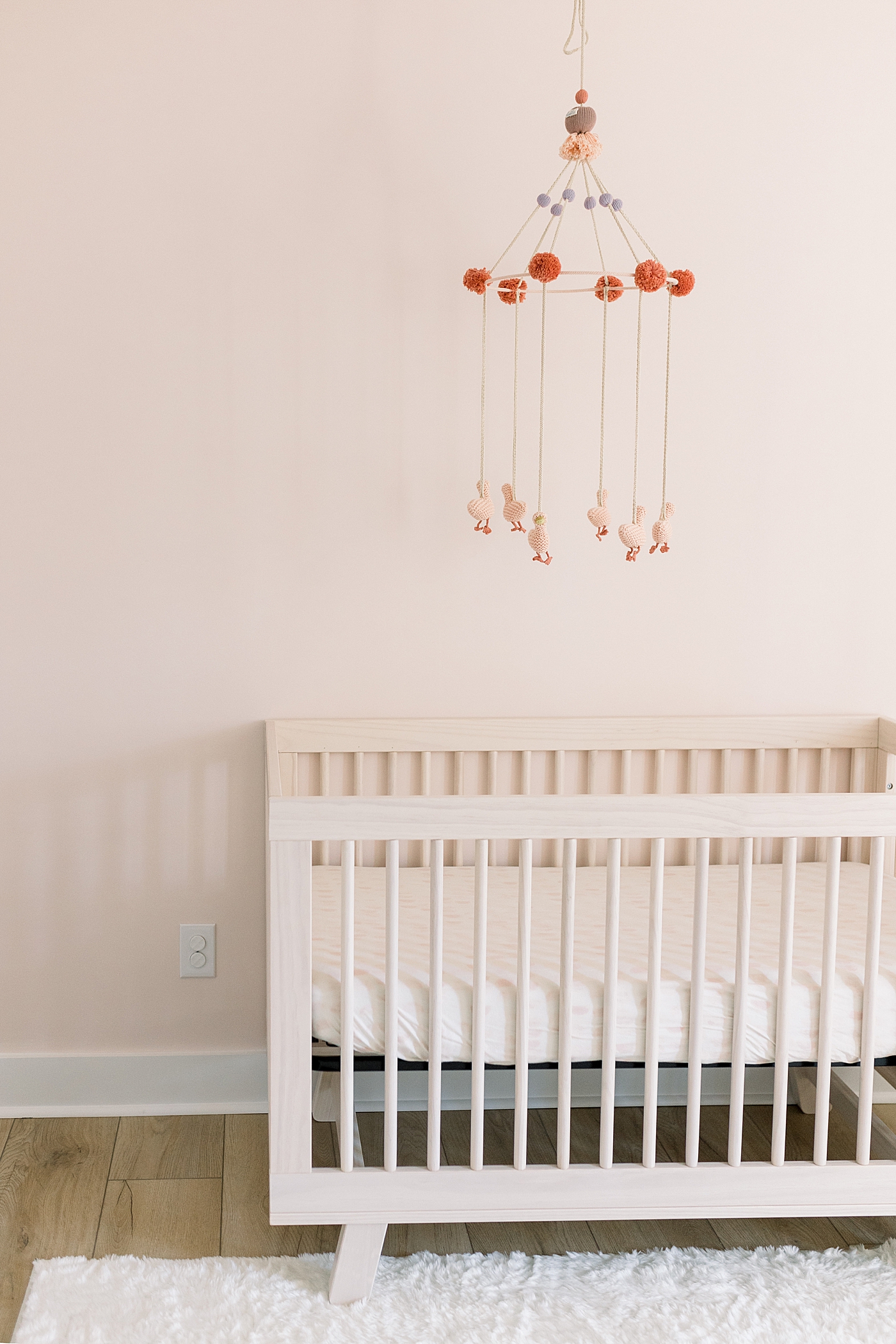 Details of baby's crib in pink nursery | Image by Caitlyn Motycka