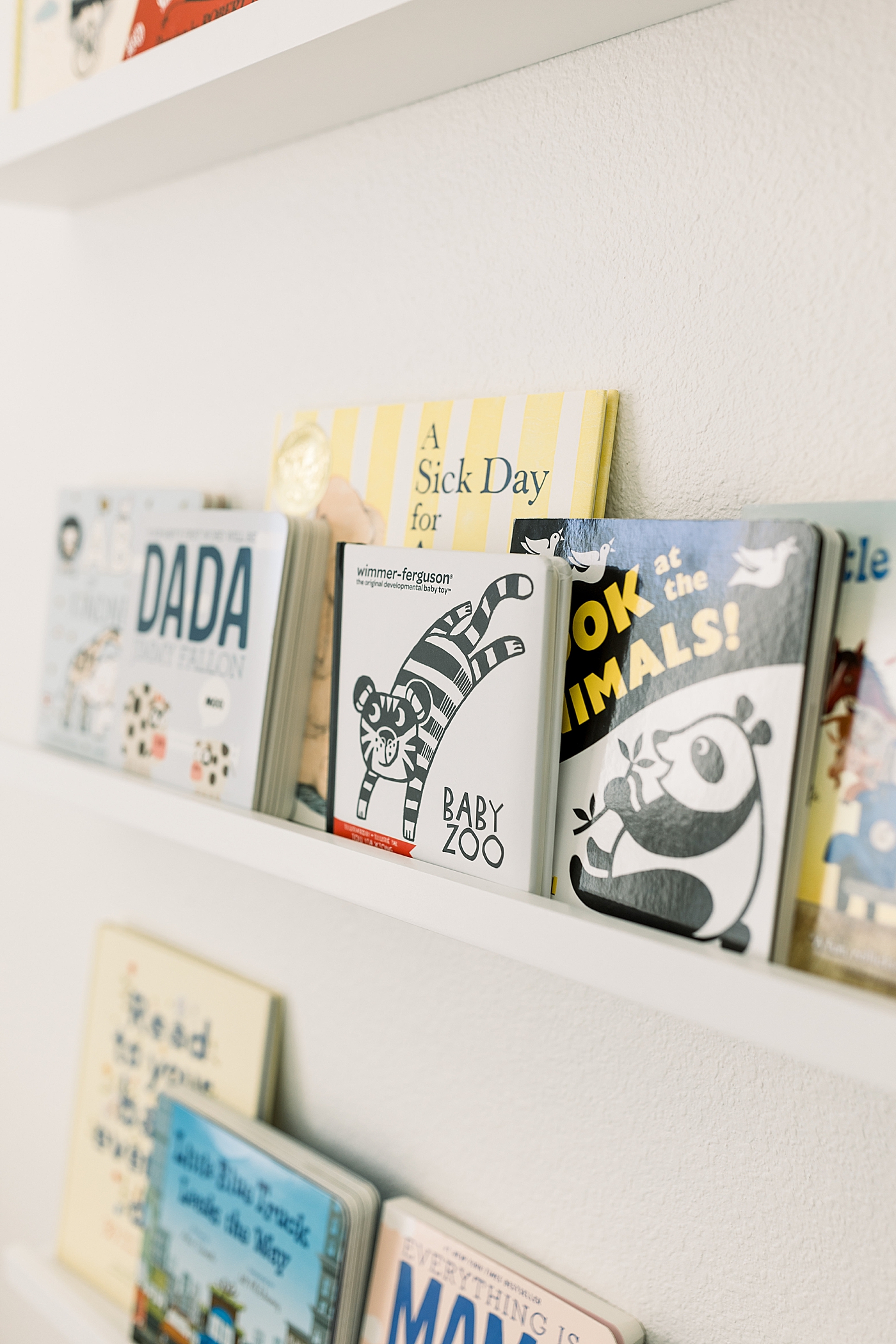 Details of baby books lineup on a shelf during baby boy newborn session | Image by Caitlyn Motycka Photography