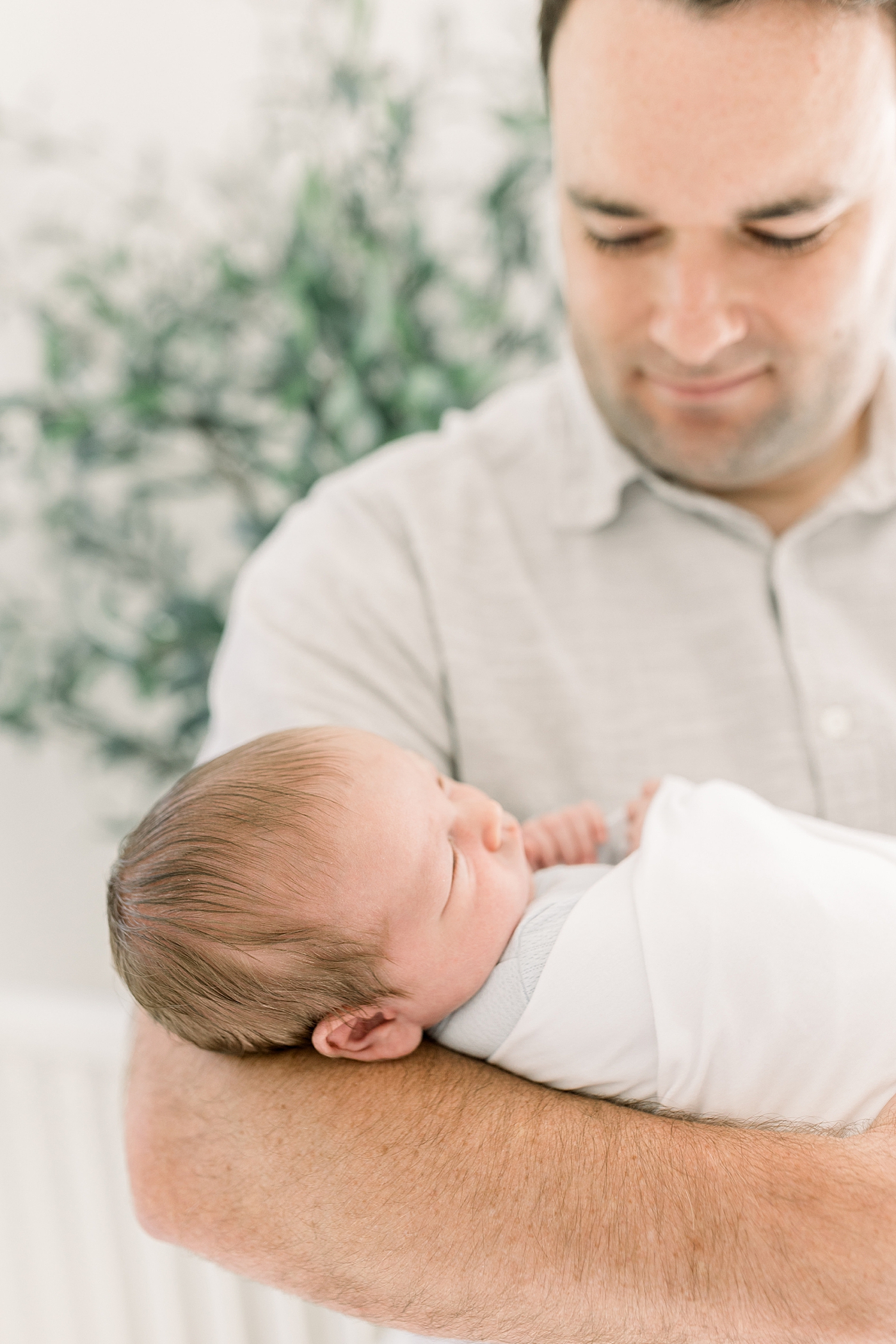 Close up of dad holding newborn during baby boy newborn session | Image by Caitlyn Motycka Photography