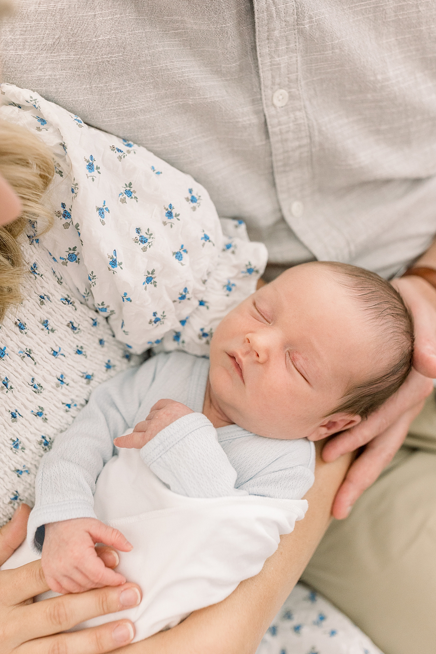 Close up overhead image of parents holding newborn boy | Image by Caitlyn Motycka Photography