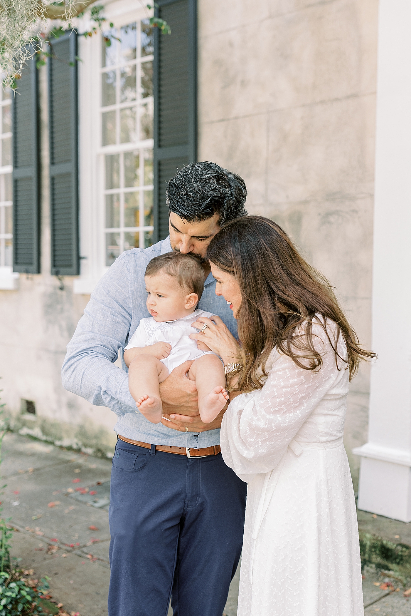 Husband and wife holding, kissing, smiling and looking at baby | Images by Caitlyn Motycka