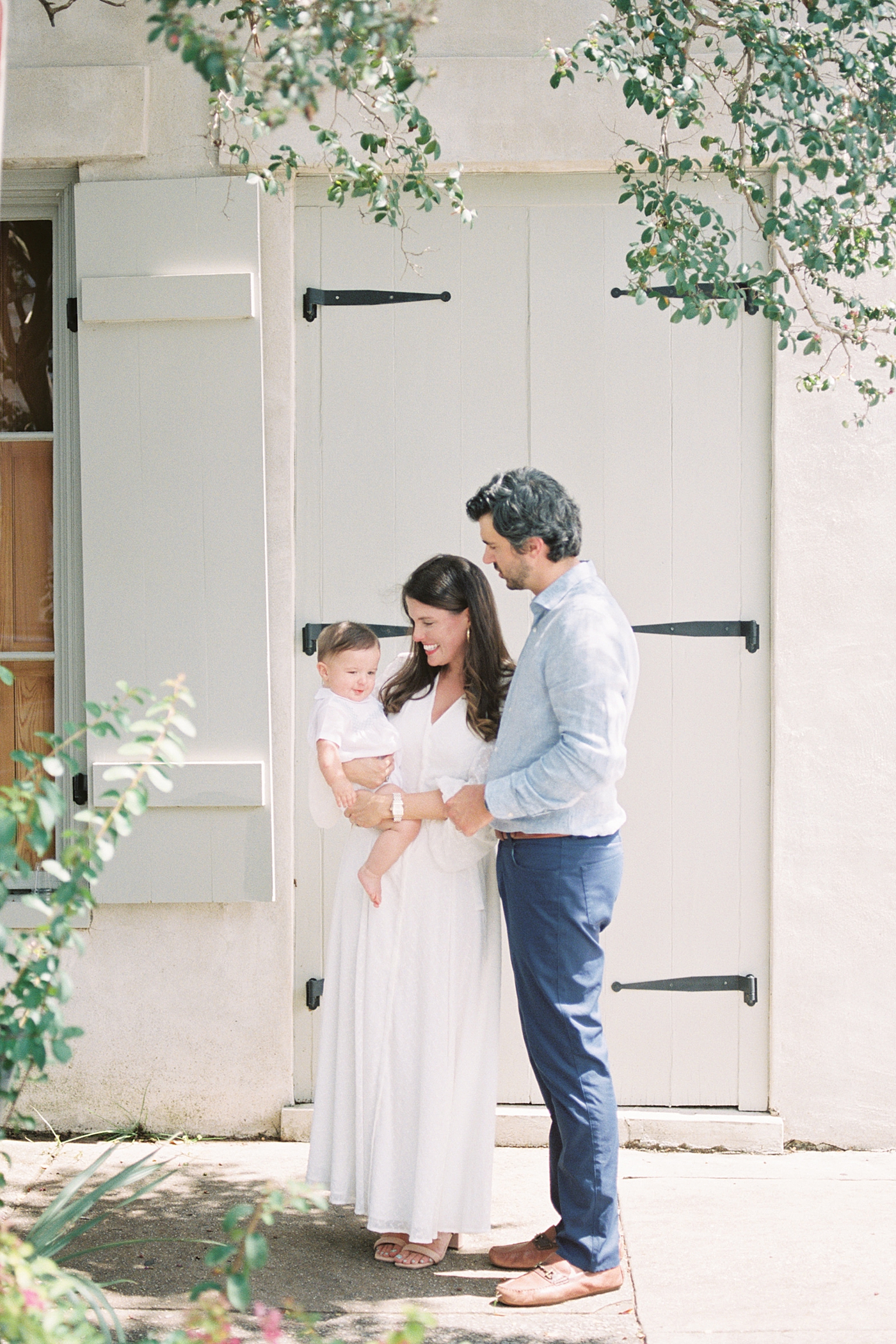 Husband and wife holding, smiling and looking at baby | Images by Caitlyn Motycka