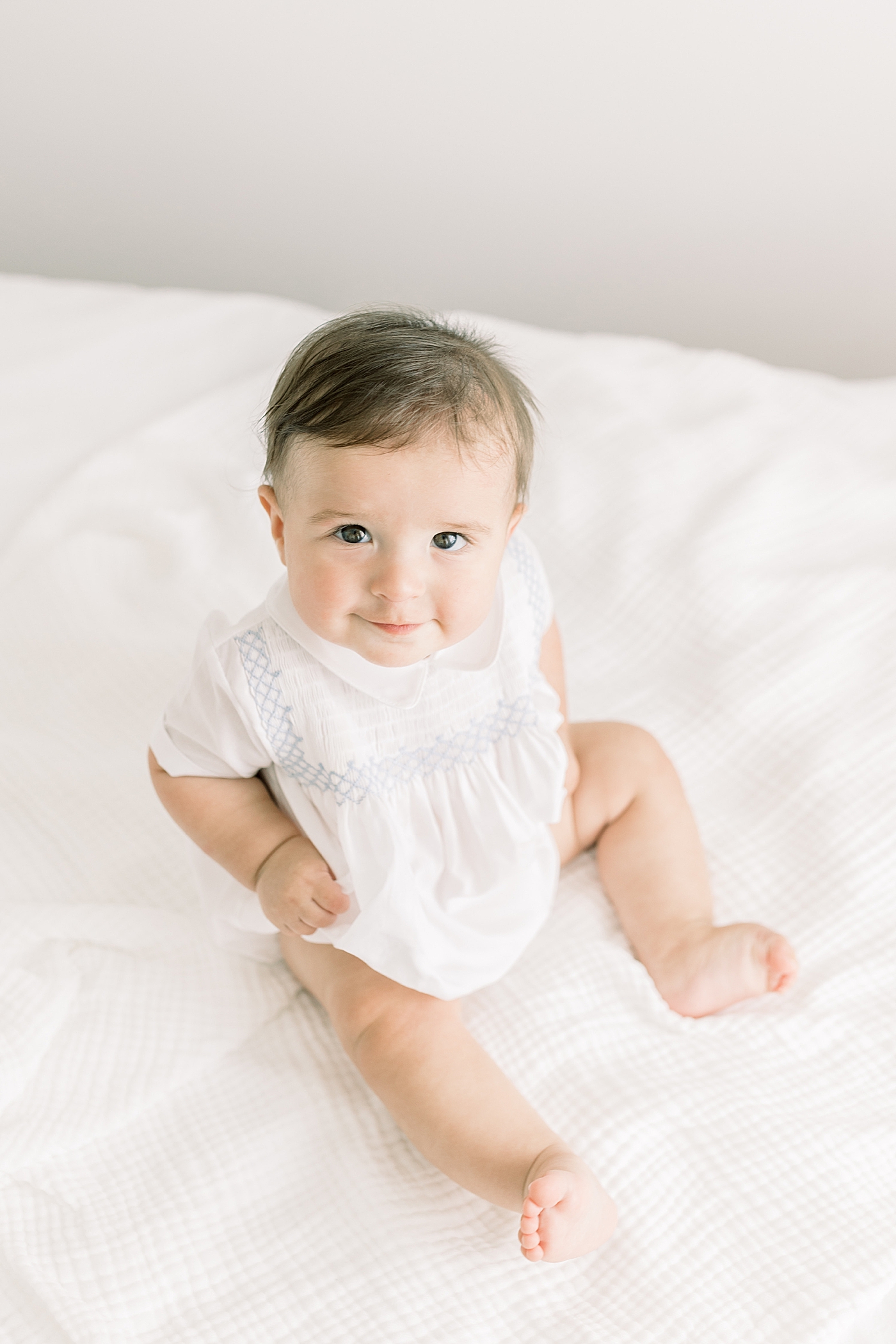 Baby smiling and looking up at camera during Studio Milestone Session | Images by Caitlyn Motycka