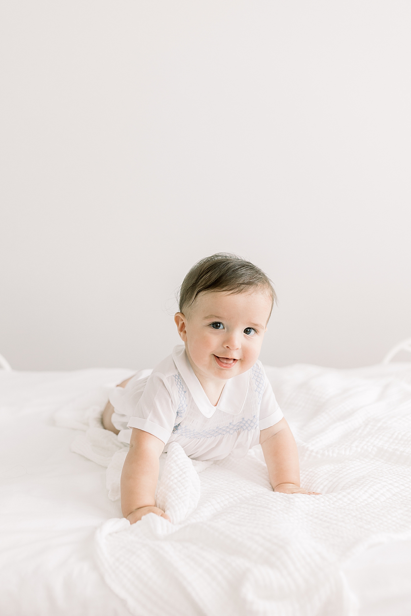 Baby looking at camera and smiling during Studio Milestone Session | Images by Caitlyn Motycka