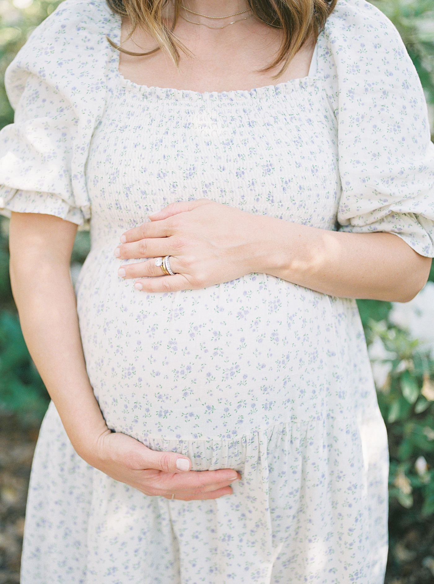 Close up of an expecting mother holding her belly during Spring Motherhood Minis in Charleston | Image by Caitlyn Motycka