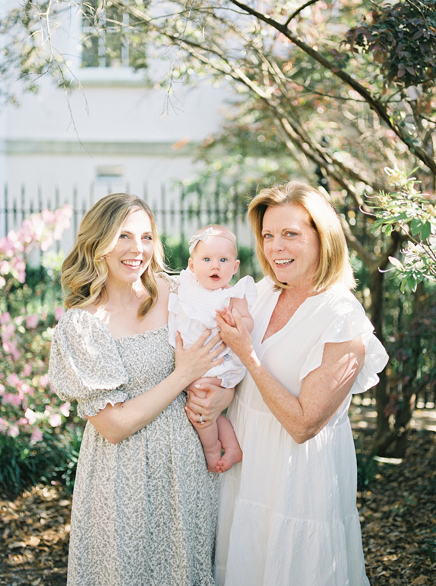 Grandmother and mother in spring dresses holding baby | Image by Caitlyn Motycka