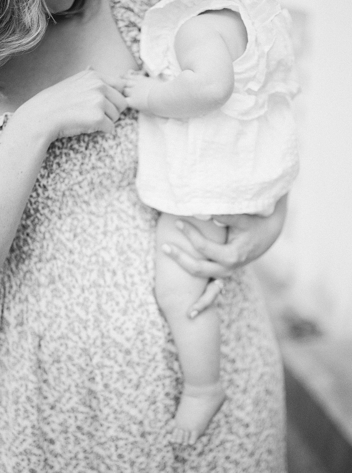 Black and white image of a mother holding her baby during Spring Motherhood Minis in Charleston | Image by Caitlyn Motycka
