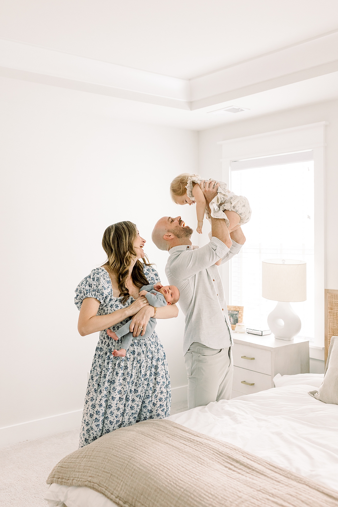 Mom and dad playing with their babies in their bedroom | Image by Caitlyn Motycka