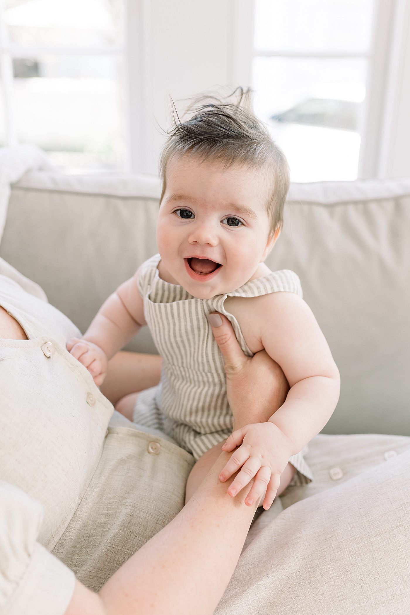 Mother holding baby, who is looking at a camera | Image by Caitlyn Motycka 